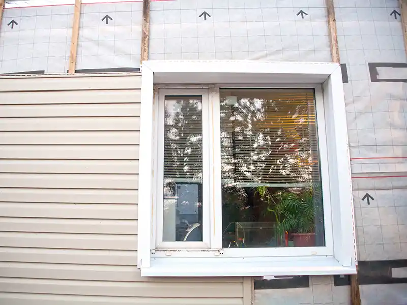 Home exterior in the process of getting new beige siding installed
